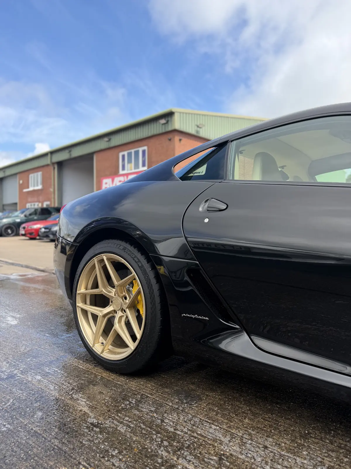 A black Lamborghini on gold wheels after detailing